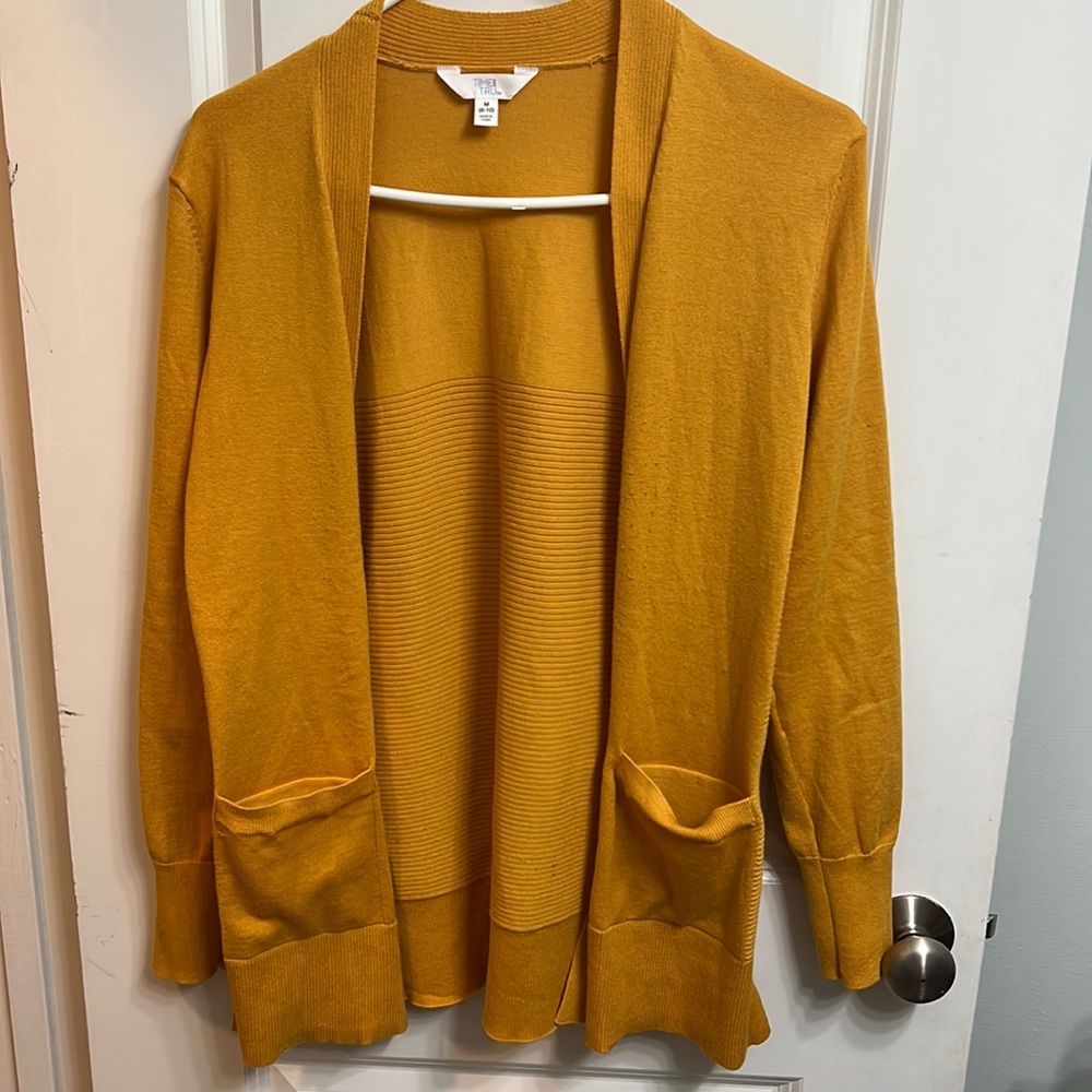 Mustard yellow cardigan somewhat fitted.